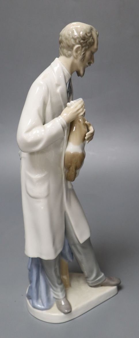 A Lladro figure, vet treating dog, 34cm